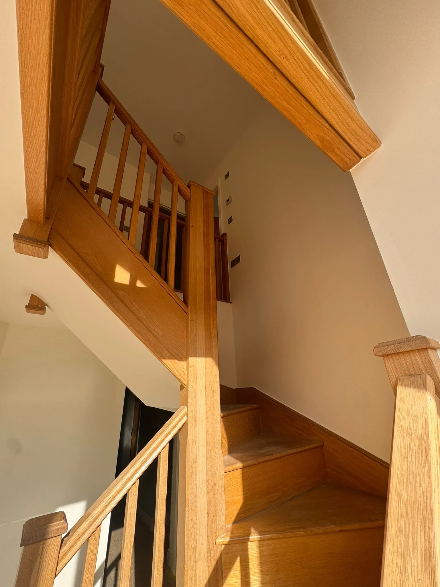 Hallway with oak staircase and crisp white walls