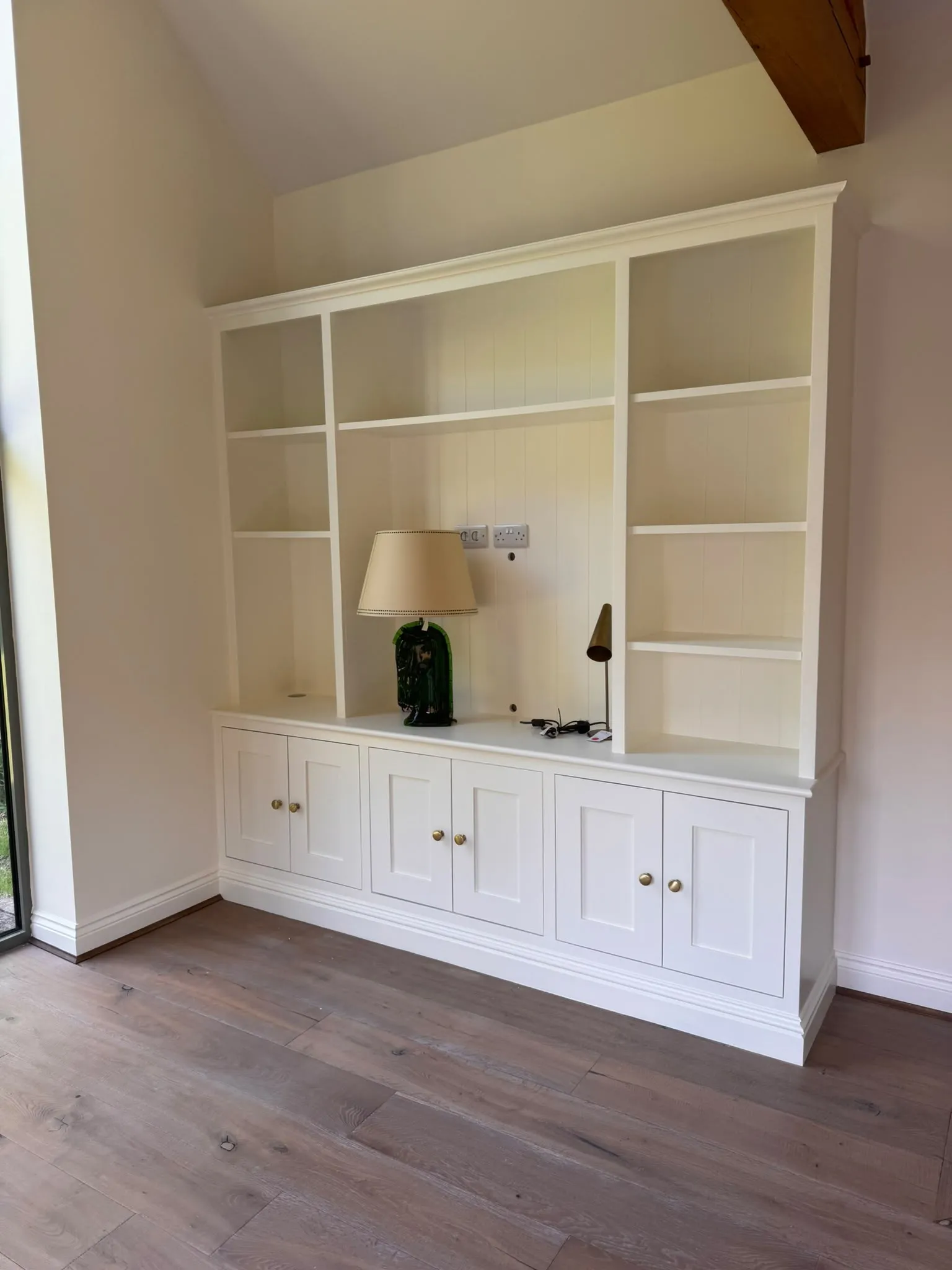 Painted built-in alcove shelving and cupboards in soft white
